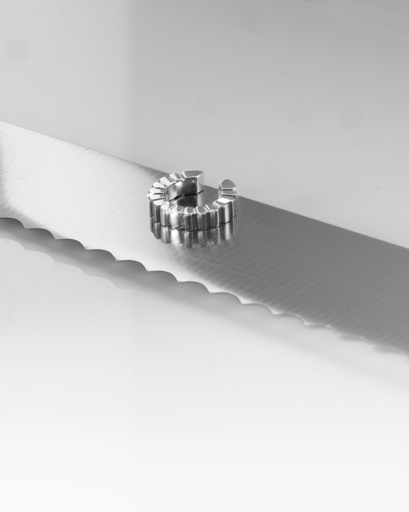 silver earcuff reflecting off knife blade