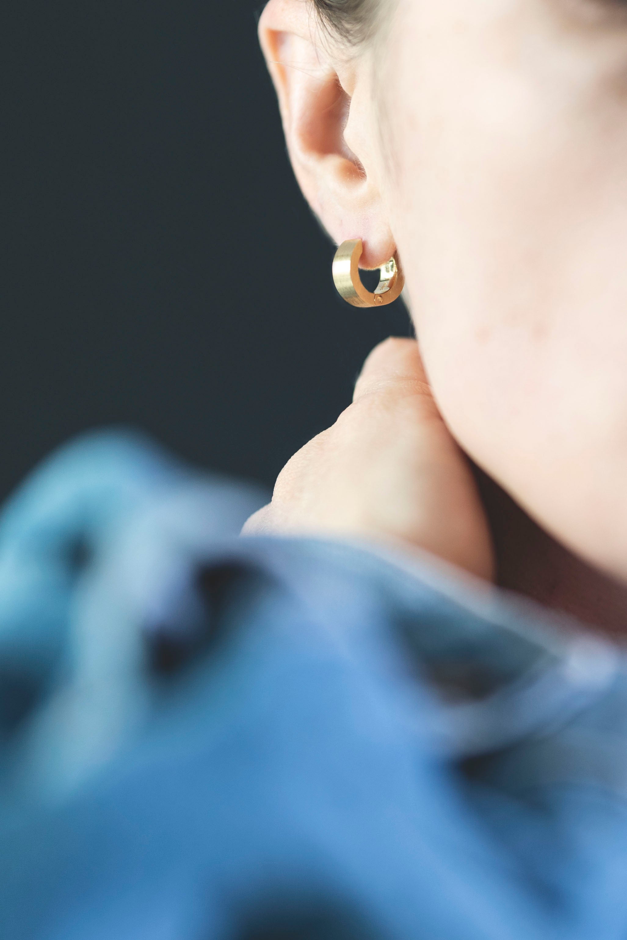 gold hoop brushed close up on ear model wearing denim