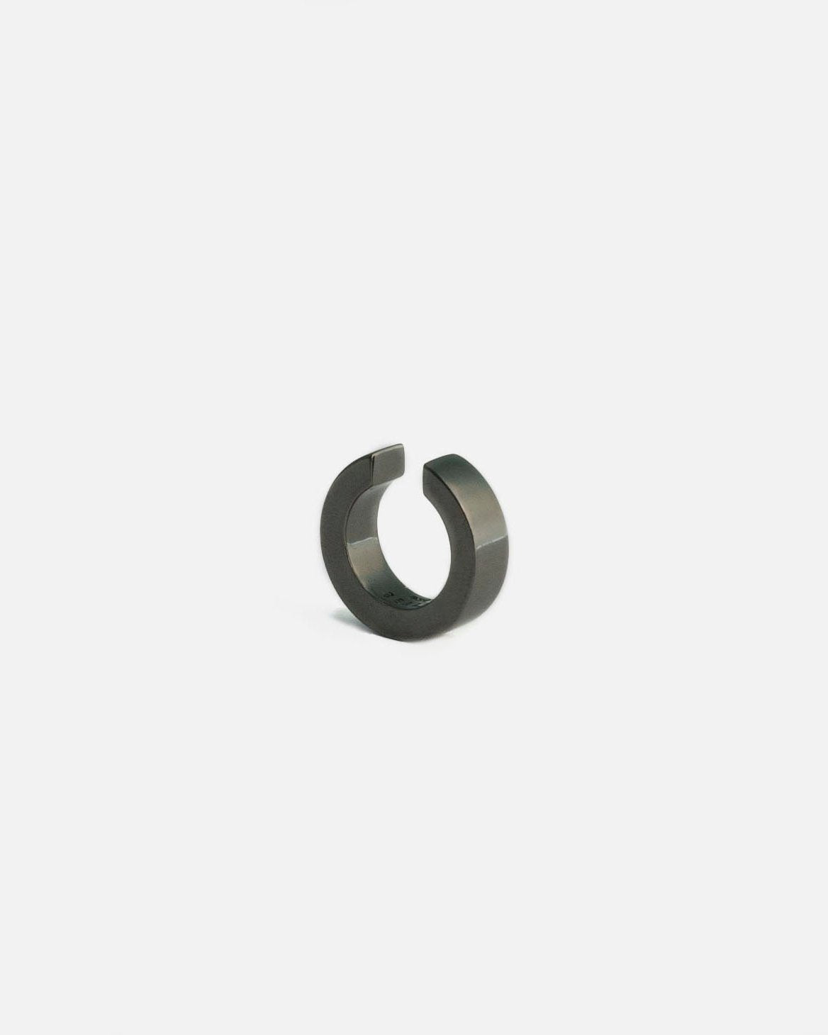 black ruthenium ear cuff on white background by studio sette