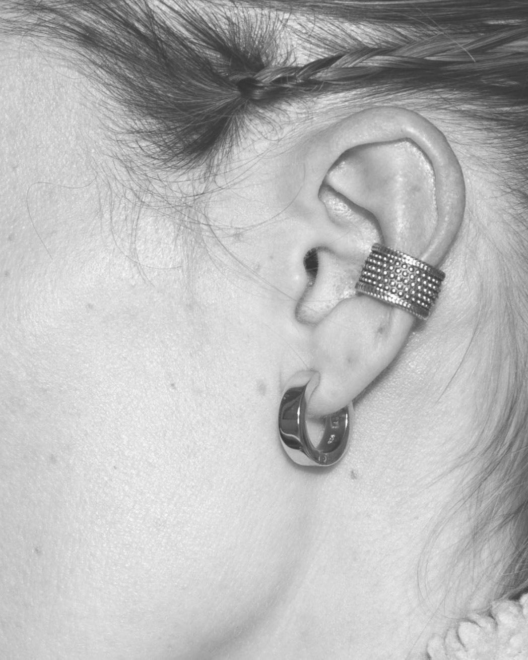 silver ear cuff and earring closeup on model ear monochrome
