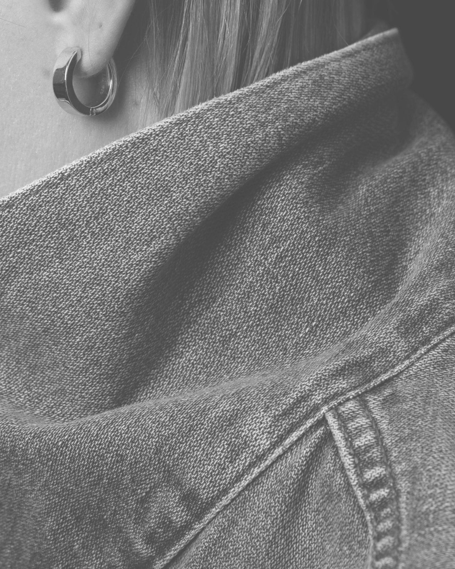 silver earring on model closeup with denim collar monochrome
