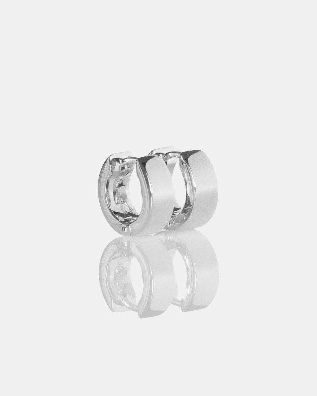pair of small unisex silver hoop earring on white background
