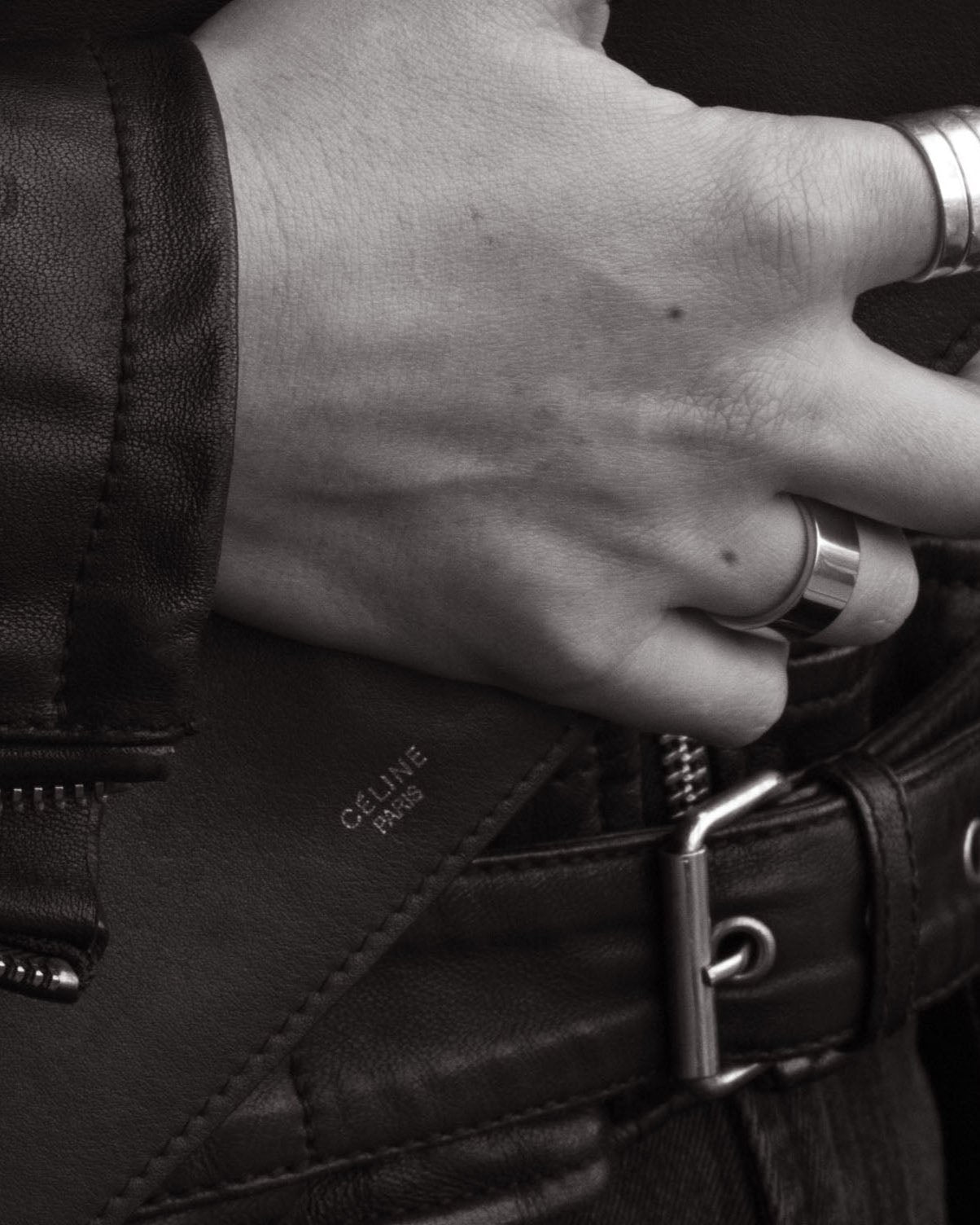 closeup unisex ring on hand resting on leather jacket monochrome