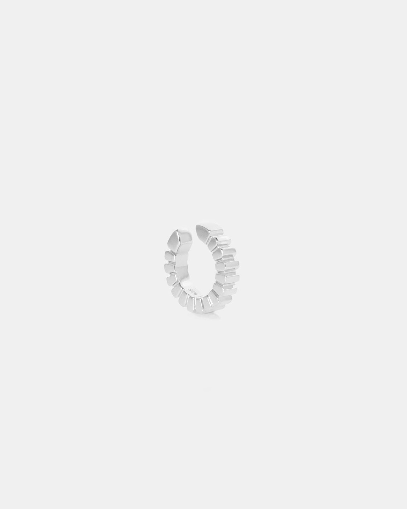silver ear cuff ridged on white background with rhodium plating by studio sette