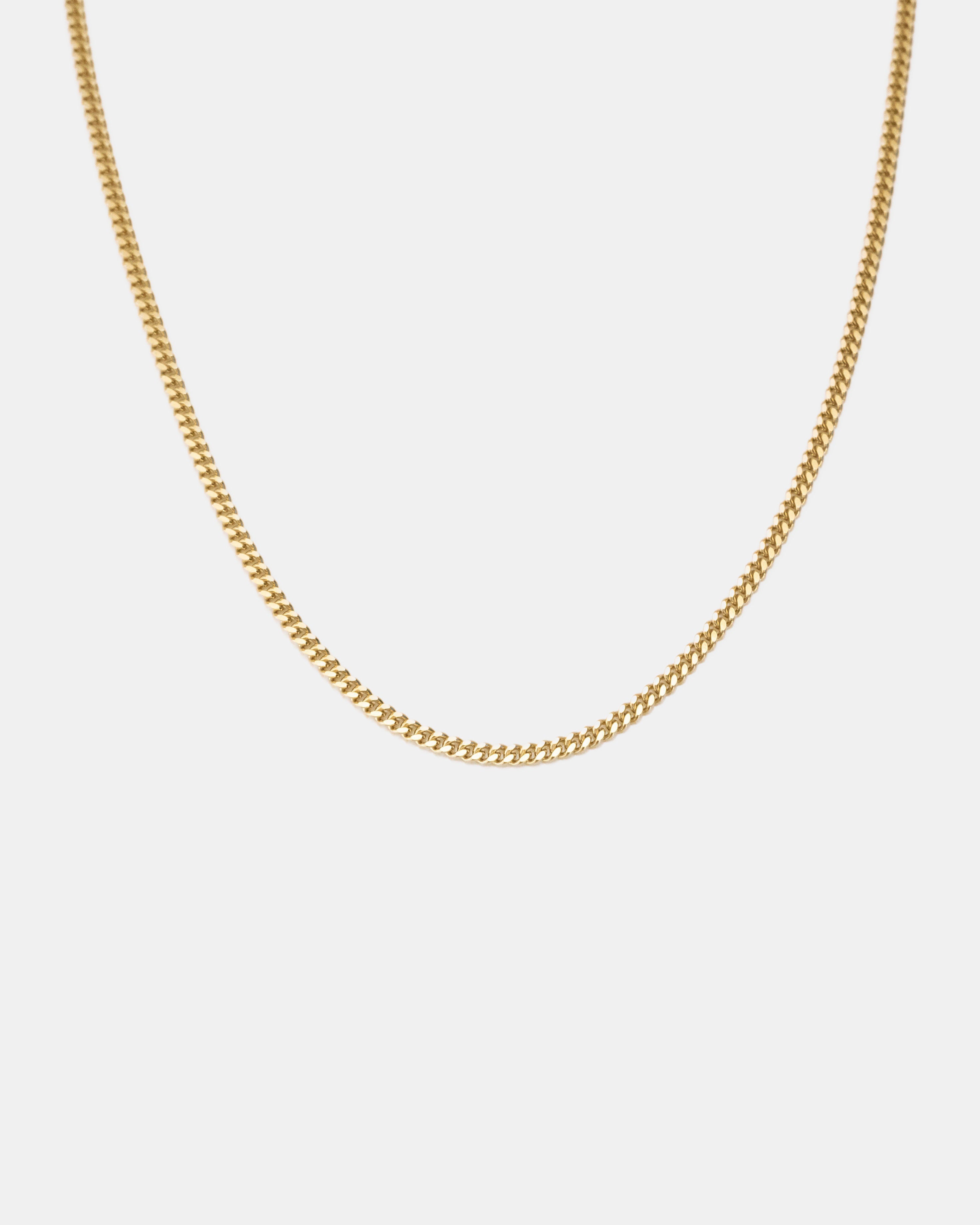 gold filed curb chain thin on white background by studio sette