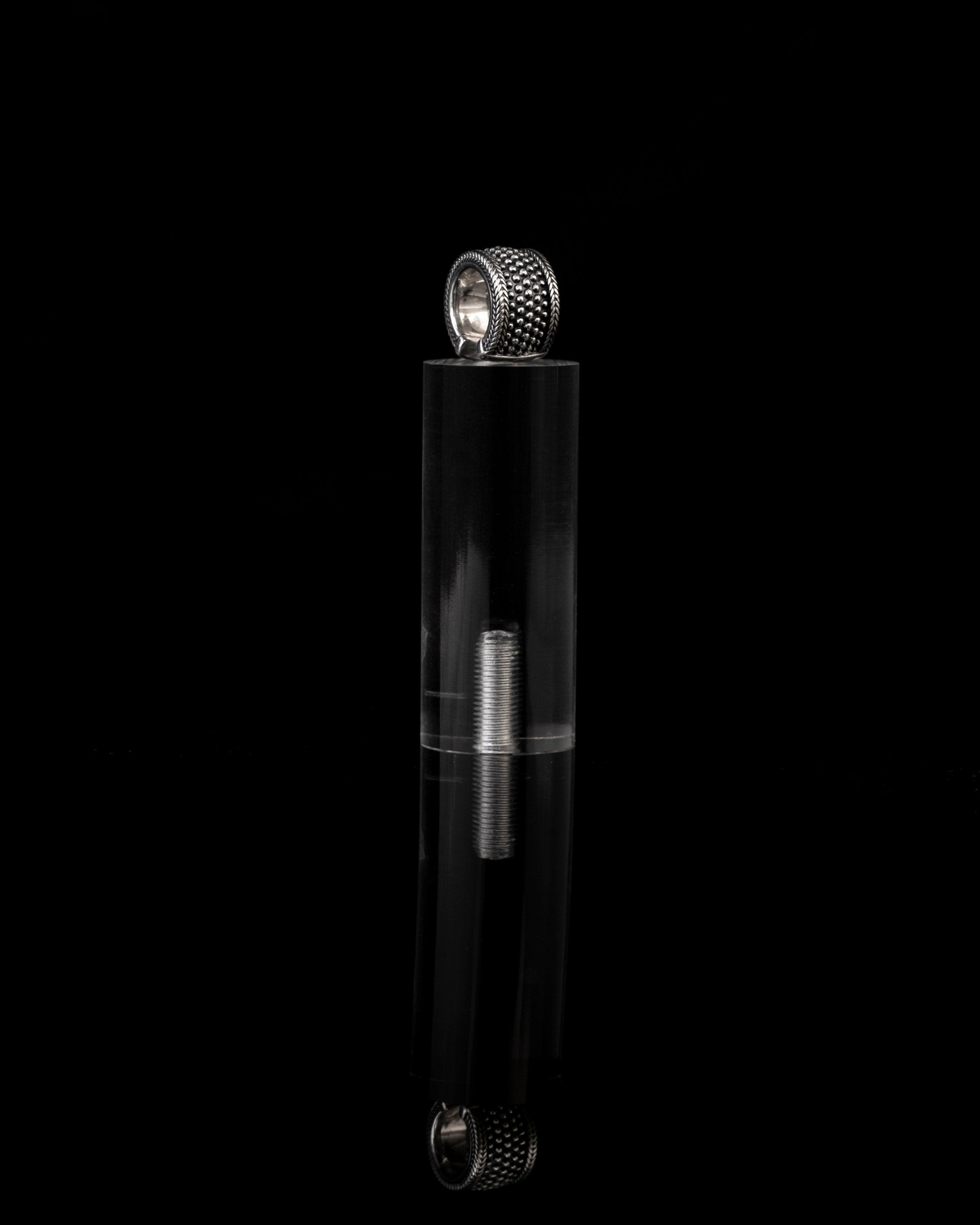 Earcuff silver on podium reflecting black mirror surface