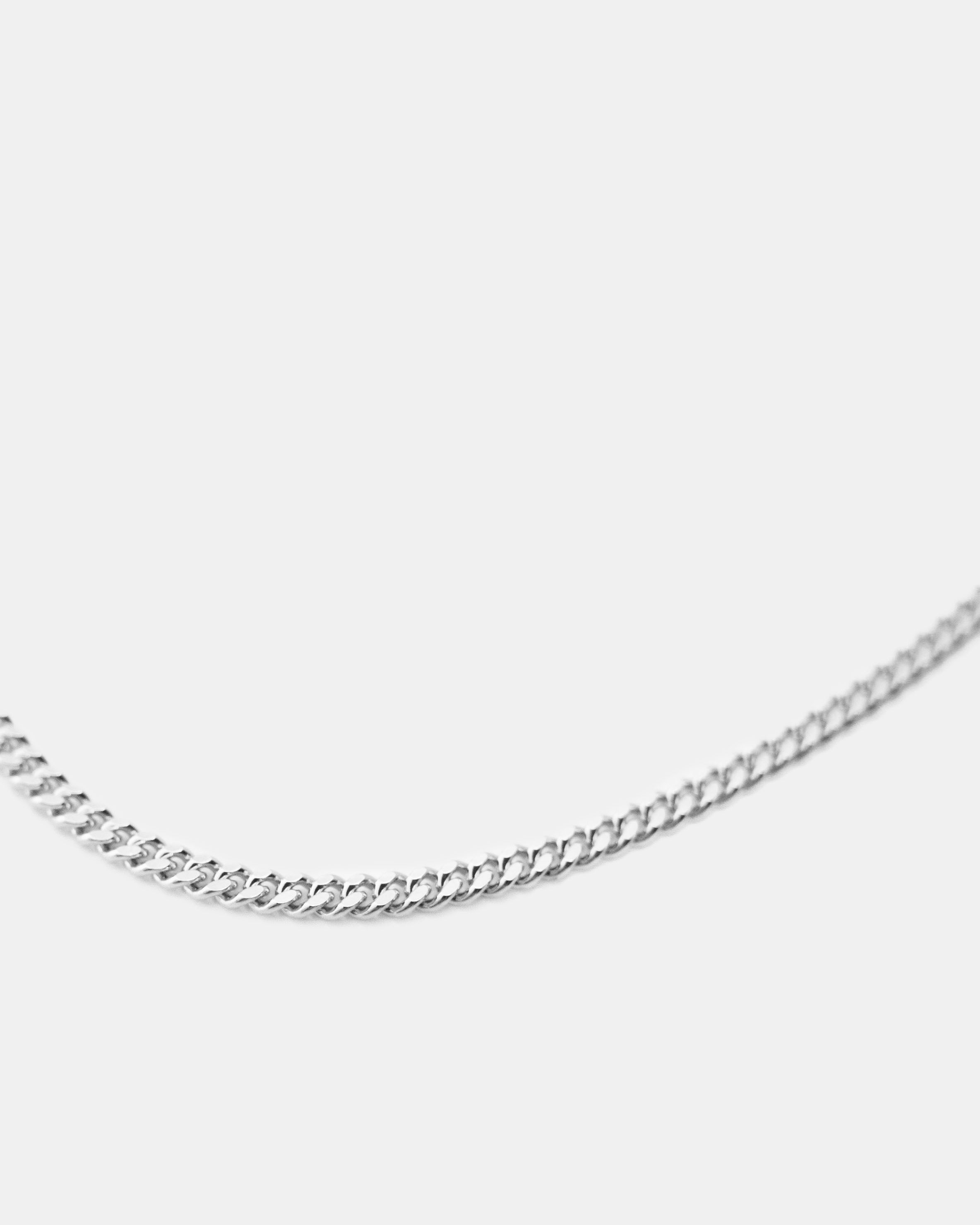 silver filed curb chain closeup on white background