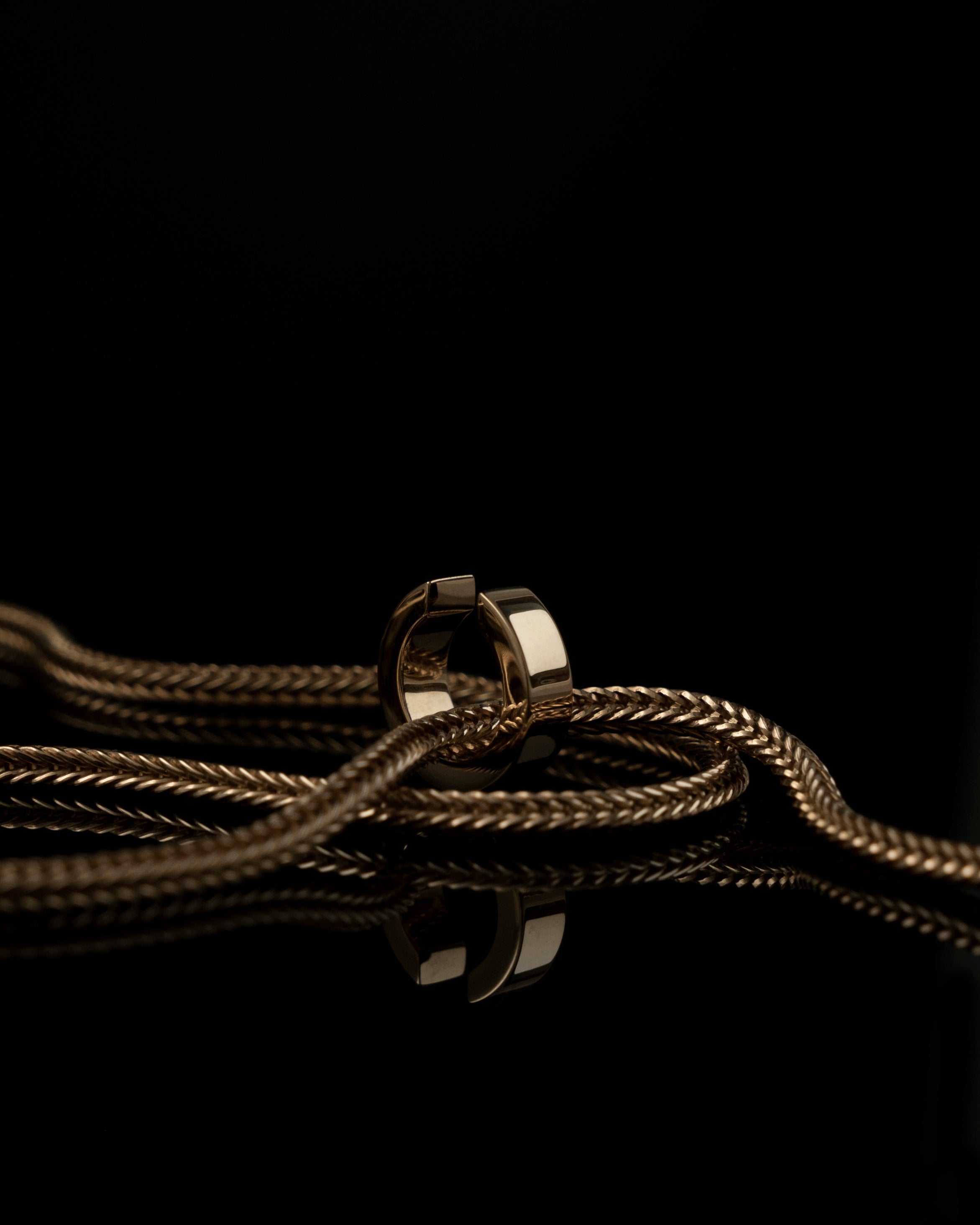 gold fox chain with ear cuff reflecting on black mirror surface