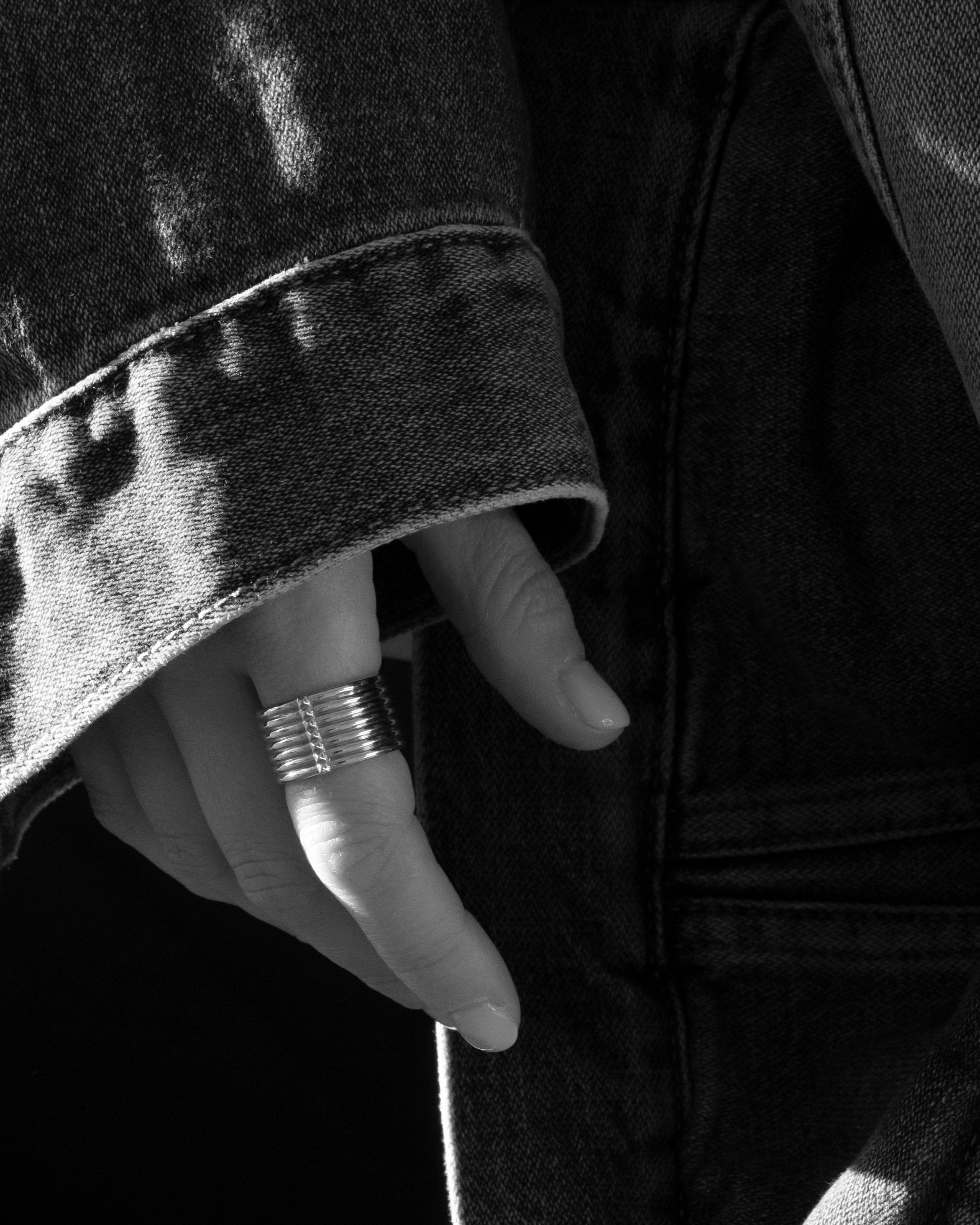 thick silver unisex ring closeup on hand with denim sleeve